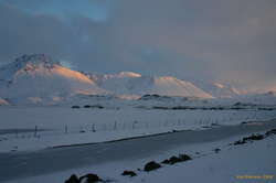Snow covered airstrip in front of the mountains
