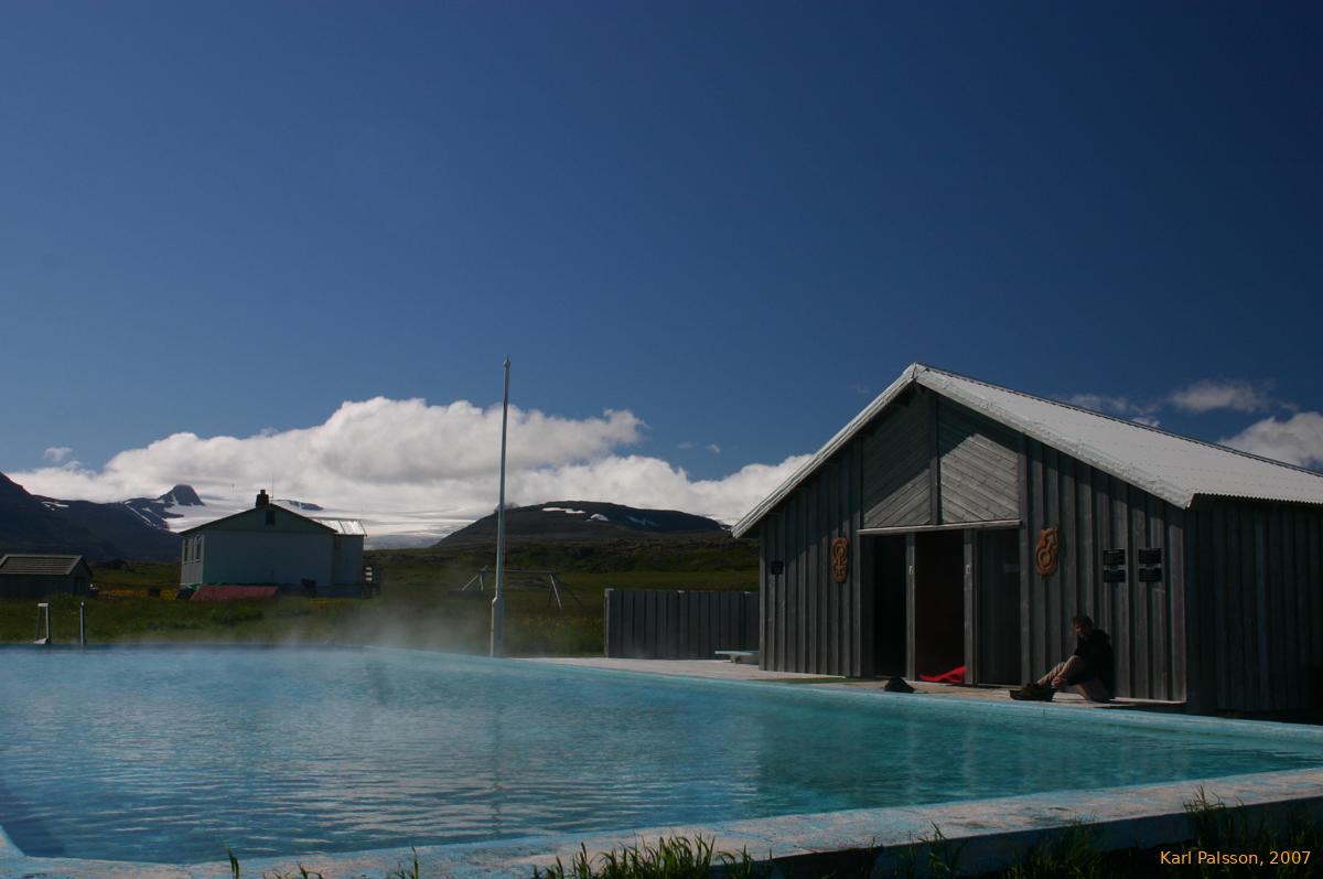 A glacier and a hot pool, under a blue sky
