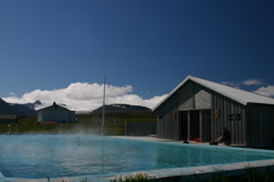 A glacier and a hot pool, under a blue sky