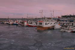 Cold sunset, ice in the small boat harbour
